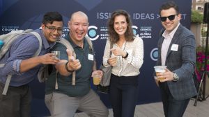 Four people stand in front of a dark blue background at the 2019 YP Summer Soiree