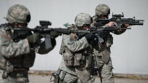 Three soldiers in camouflage holding weapons