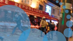 A blurred motion image of people in front of a European bar at night time