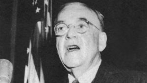 A black and white photo of John Foster Dulles speaking at a podium.