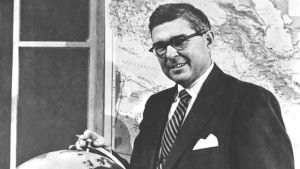 A black and white photo of Carter Davidson and a globe.