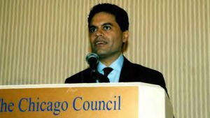 Fareed Zakaria speaks in a microphone behind a podium.