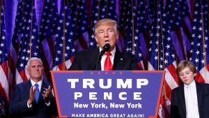 Donald Trump speaks into a microphone behind a podium