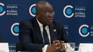 Nana Akufo Addo speaking into a microphone while sitting down