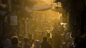 A street market in Syria with pedestrians and a hazy sunset