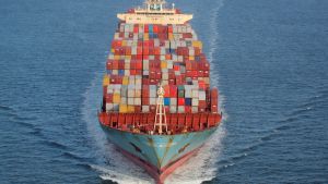 Containers are stacked on the deck of the cargo ship on the ocean.