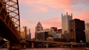 View of Pittsburgh at sunset near a bridge.