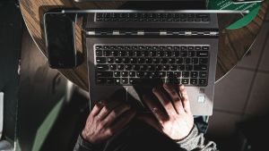 View of a person's hands typing on a laptop