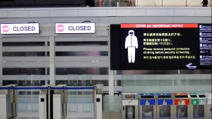 A notice about COVID-19 safety measures is pictured next to closed doors at a departure hall of Narita international airport 