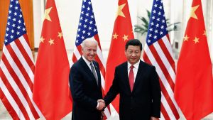 President Biden and Xi Jinping shaking hands in front of flags in 2013.