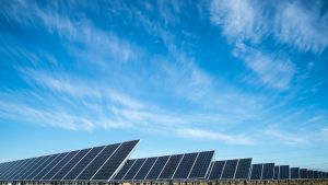 Rows of solar panels in front of a blue sky