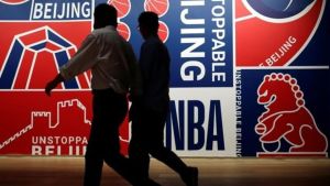 Silhouettes in front of a wall banner for red, blue, and white Beijing NBA images