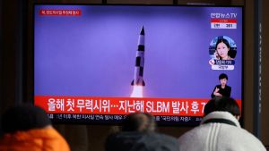 Spectators watch news video footage of missile test in Korea.