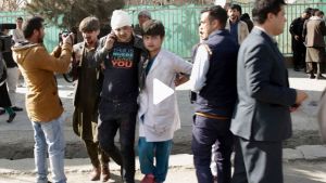 Injured people are seen walking through a busy street