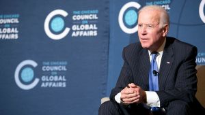 Joe Biden sits in a chair onstage during a Council event.