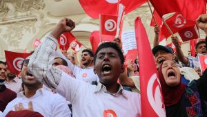 Protestors wave red flags in Tunisia.