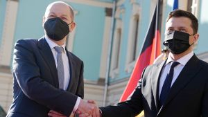 Two men wearing face masks shake hands
