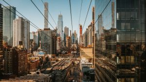 City skyline of New York City with reflective buildings and cable wires. 