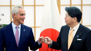 Japan's Foreign Minister Yoshimasa Hayashi (R) fist bumps with new US ambassador to Japan Rahm Emanuel 