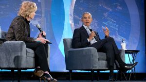 Two people sitting in chairs while talking into microphones