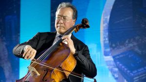 A man playing a cello with his eyes closed