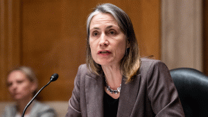 Fiona Hill speaking at a microphone seated. 