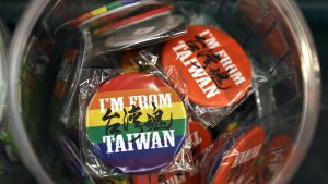 Close up of bin of rainbow buttons that say "I'm From Taiwan."