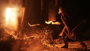 A worker throws coal into the smelting furnace at a steel mill in Ukraine's eastern city of Donetsk