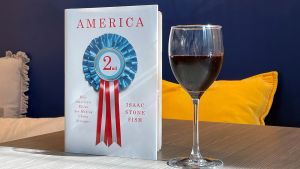 Book cover of America Second, with a glass of wine next to it