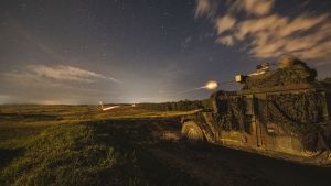 .50 caliber machine gun fires on top of a tank during a combined arms live-fire exercise at night.