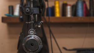 Close up of a sewing machine in front of thread