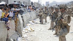 Marines keep security as civilians wait for processing during the evacuation of non-combatants at Hamid Karzai International Airport in Kabul, Afghanistan.