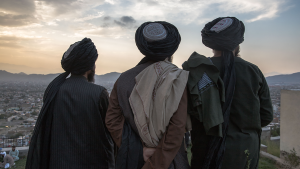 Three men overlooking a city and sunrise.
