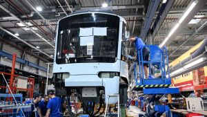 Workers in a factory building a vehicle