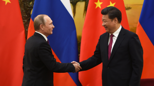 Against a backdrop of Russian and Chinese flags, Russian President Vladimir Putin shakes hands with Chinese President Xi Jinping at the end of a joint press briefing in Beijing's Great Hall of the People.