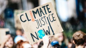 a sign that says climate justice now!