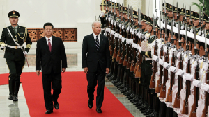 Chinese President Xi Jinping and US President Joe Biden walk together at a Chinese ceremony.