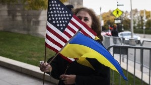 A woman holds US and Ukrainian flags