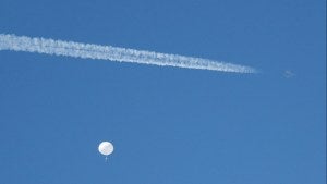 A jet flies by a suspected Chinese spy balloon as it floats off the coast in Surfside Beach