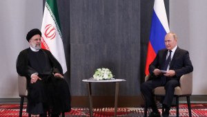  Russian President Vladimir Putin (right) met with Iranian President Ebrahim Raisi (left) seated in front of flags from each country.