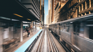 A Chicago elevated train car drives along the tracks through a station