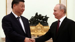 Russian President Vladimir Putin shakes hands with Chinese President Xi Jinping 