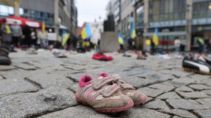Children's shoes and people with Ukrainian flags