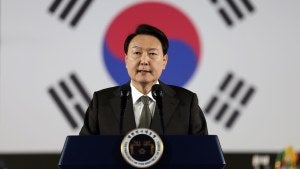 Yoon Suk-Yeol stands in front of a South Korean flag