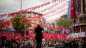 Kemal Kilicdaroglu speaks at a campaign rally in Tekirdag, shown from behind in front of a crowd with many red flags.