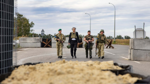 Director Bernard-Henri Lévy walking with three soldiers.