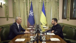 NATO Secretary General Jens Stoltenberg and Ukrainian President Volodymyr Zelenskyy sit at a table