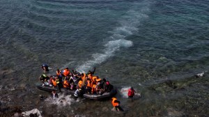 Migrants and refugees arrive by dinghy after crossing from Turkey to the island of Lesbos, Greece.