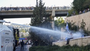 Israeli police use a water cannon to disperse demonstrators blocking a road during a protest against plans by Prime Minister Benjamin Netanyahu's government to overhaul the judicial system