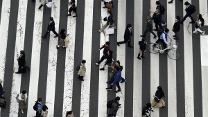People walk along a pedestrian crossing in Japan.